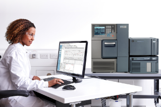  Scientist sitting at desk with ACQUITY System