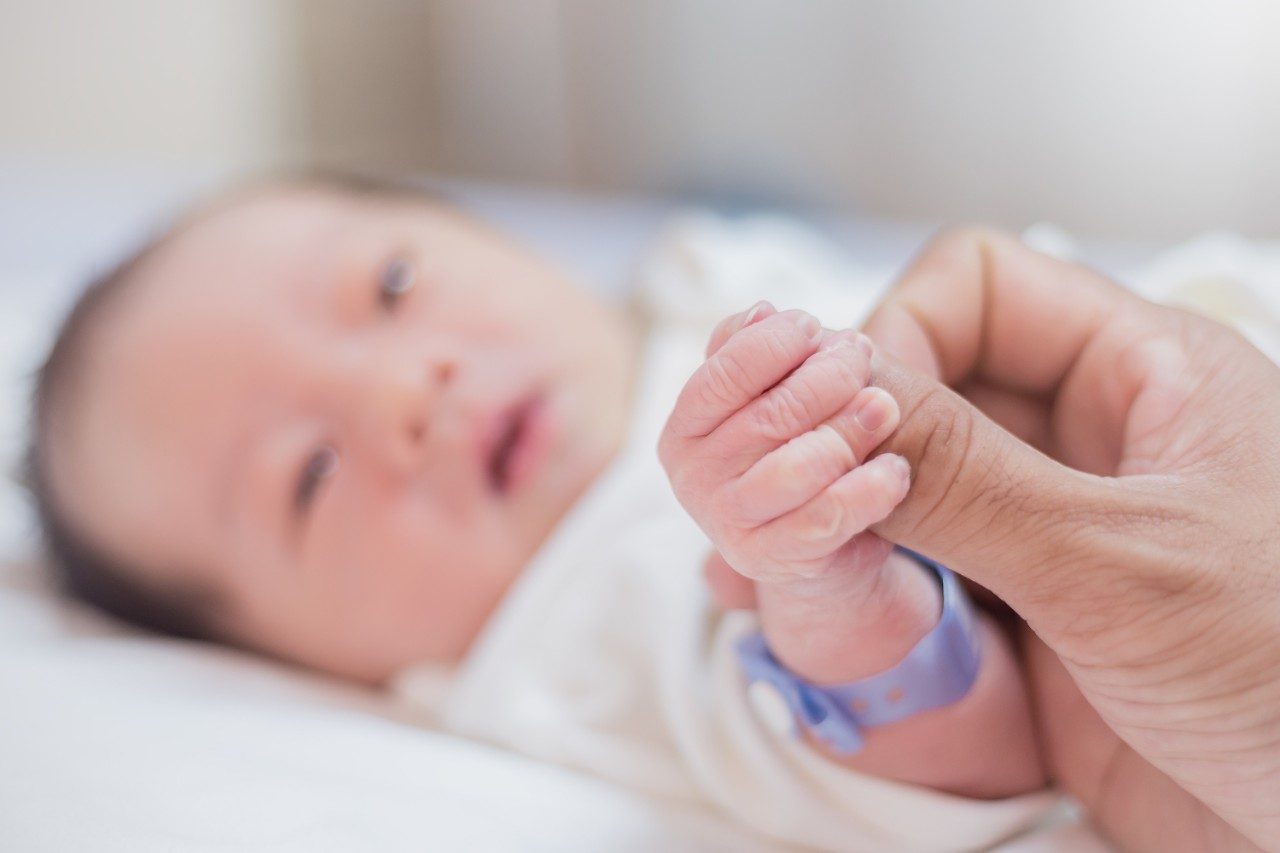 Hand holding newborn baby fingers