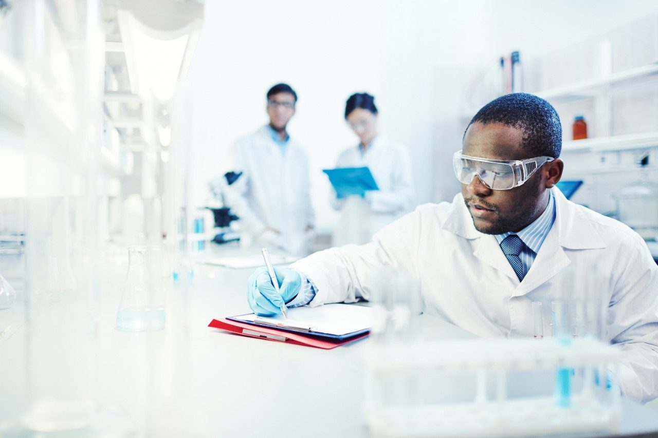 Scientist writing notes in lab